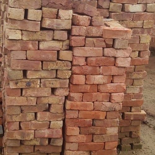 Dense hard-fired Chatka bricks stacked for foundation and trench masonry supply